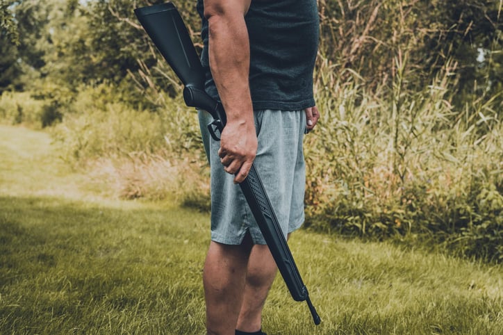 man holding an air rifle side view
